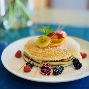 a stack of pancakes with fruit on top