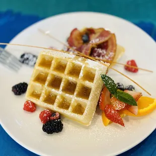 a waffle on a plate with fruit