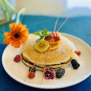 a stack of pancakes with fruit on top