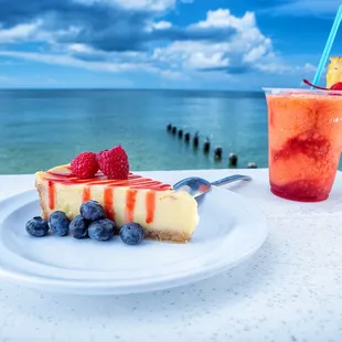 a slice of cheesecake and a drink on a table