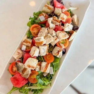 a salad with chicken and tomatoes