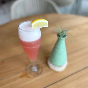 a glass of wine with a lemon wedge