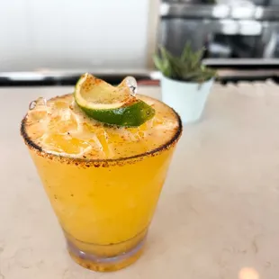 a cocktail with a lime garnish
