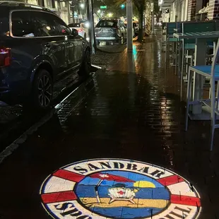 The sidewalk image on a rainy sidewalk makes it looks like you&apos;re in a movie.