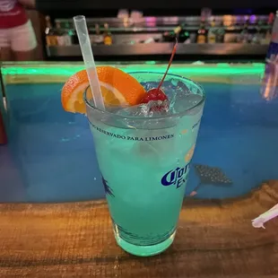 a blue drink with an orange slice