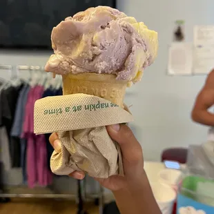 a hand holding a cone of ice cream