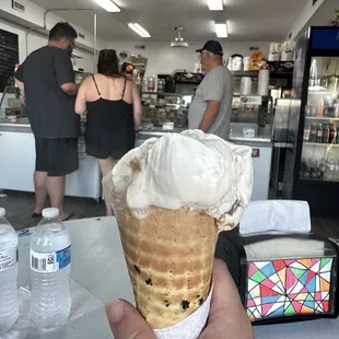 a hand holding an ice cream cone