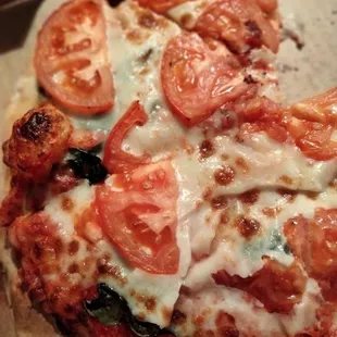 Margherita pizza: fresh basil and tomatoes with a touch of garlic and olive oil
