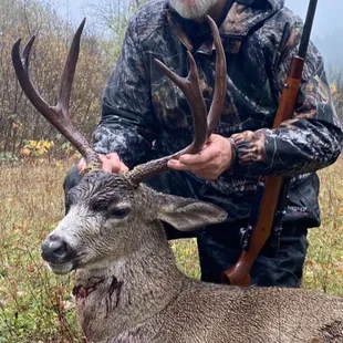 a man posing with a deer