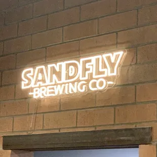 a neon sign on a brick wall