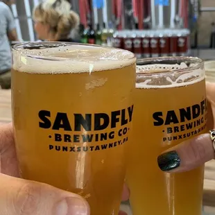 two people holding glasses of beer