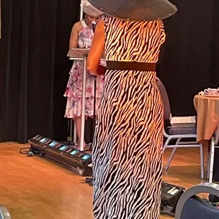 a woman in a zebra print dress and hat