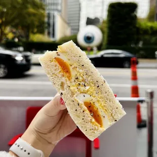 a person holding a sandwich in their hand