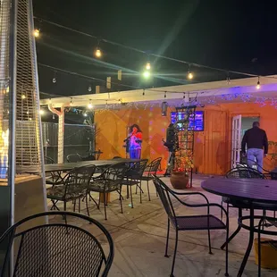 a patio area with tables and chairs