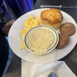 Eggs, grits, sausage patties, and biscuit