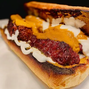 a meatball sandwich with cheese and sauce