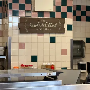 a kitchen with a sign above the counter