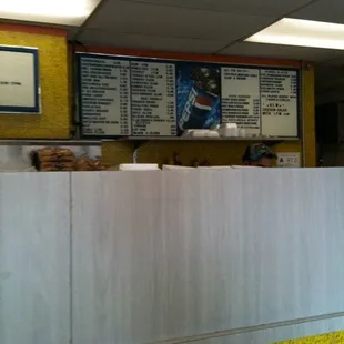 a counter with a menu on the wall