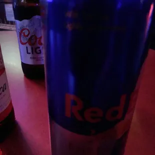 a can of red bull and a bottle of beer