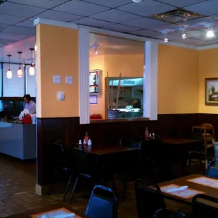 The larger dining area is partially separated from the entrance and counter