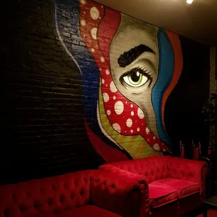 a red couch with a woman&apos;s face painted on it