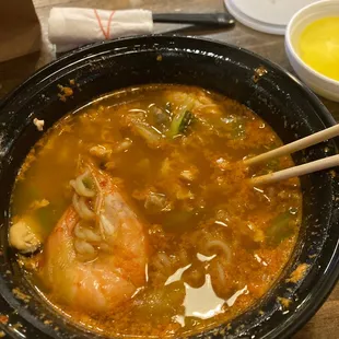 a bowl of soup with chopsticks