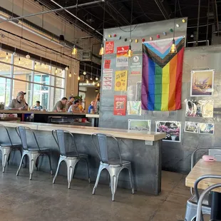a bar with a rainbow flag hanging from the ceiling