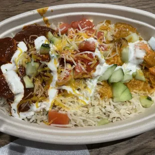 Curry bowl with chicken tikka, half tikka masala half vindaloo, with cucumber, tomato, cheese, and yogurt sauce. Yum!