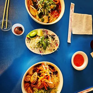 three bowls of food on a blue table
