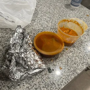 a bowl of soup and a container of sauce