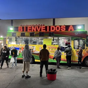 a group of people standing in front of a food truck