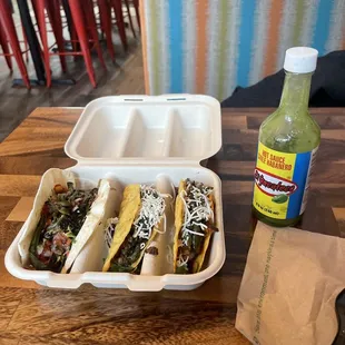 three tacos in a styrofoam container