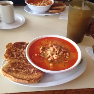 a bowl of soup and two grilled cheese sandwiches