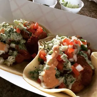 Fish tacos with pico de gallo, cabbage, cilantro and chipotle sauces, and a squeeze of lime.