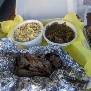 Tender pulled pork with potatoes salad and collard greens and given a small side of seasoned rice