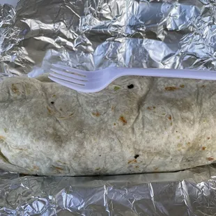 Cachete Santa Burrito. Fork for scale. They say this is enough for 2. It is no joke! Plus it is super messy, which is a plus to me. 10/10!
