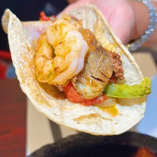 a hand holding a tortilla