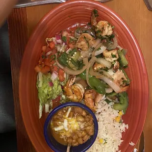 Shrimp mixed with veggies, guacamole, rice and beans