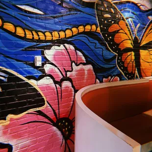 a mural of a butterfly on a brick wall