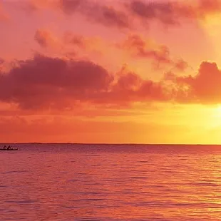 a boat in the ocean at sunset