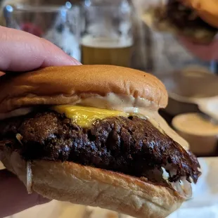 a hand holding a hamburger