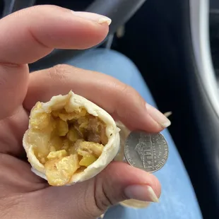 a hand holding a half eaten burrito