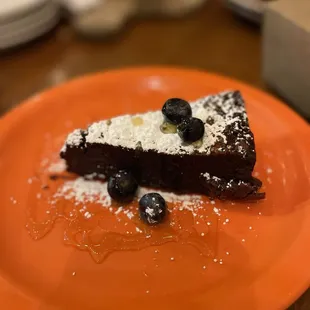 a piece of chocolate cake on an orange plate