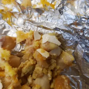 a closeup of a burrito wrapped in foil