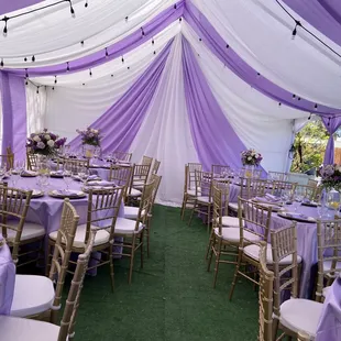 Tent with draping string lights tables gold Chiavari chairs silverware plates chargers napkins etc