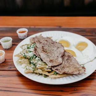 Chilaquiles con Carne: Spicy green chilaquiles served with steak.