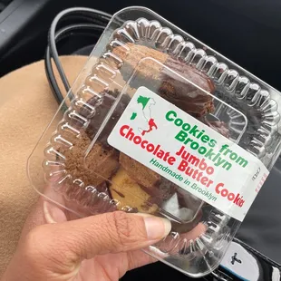 a person holding a container of cookies