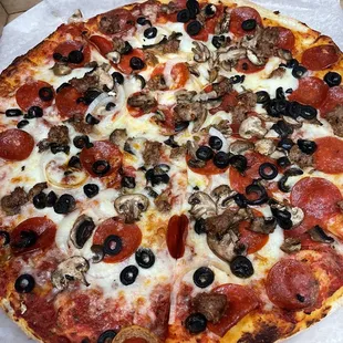 Pepperoni, sausage, mushroom, olive, and onion pizza