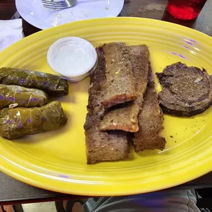 a plate of meat and grape rolls
