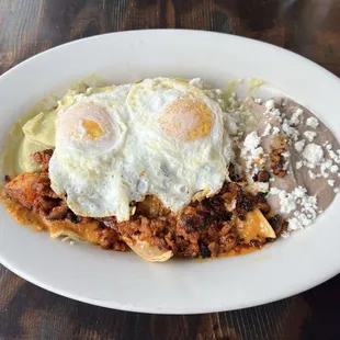 Chilequiles with Al pastor and beans. I wasn&apos;t a big fan of the tomatillo sauce and the meat was chopped into pieces.